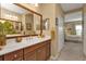 Bathroom showcasing a large mirror over the vanity and a doorway leading to the bedroom at 1339 Backspin Dr, Englewood, FL 34223