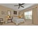 Inviting bedroom featuring a ceiling fan, upholstered headboard, and a cozy window seat at 1339 Backspin Dr, Englewood, FL 34223