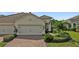 Home with a brick paver driveway, a two-car garage and beautifully maintained landscaping at 1339 Backspin Dr, Englewood, FL 34223