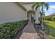 Inviting front entry with brick walkway, lush greenery, and covered porch at 1339 Backspin Dr, Englewood, FL 34223
