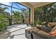 Screened-in patio with comfortable seating offers serene views of the surrounding greenery and pond at 1339 Backspin Dr, Englewood, FL 34223