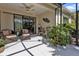 Covered patio features a ceiling fan, comfortable seating, and views of lush landscaping at 1339 Backspin Dr, Englewood, FL 34223