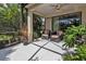 Screened-in lanai with ceiling fan, chairs, and leafy landscaping offering privacy at 1339 Backspin Dr, Englewood, FL 34223