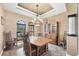 Cozy dining room with a traditional wooden table, chandelier, and natural light from the windows at 15092 Chinook Way, Port Charlotte, FL 33981