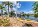 Scenic waterfront dock with a boat lift and lush landscaping at 15092 Chinook Way, Port Charlotte, FL 33981