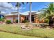 Charming home with lush landscaping, palm trees, and a well-manicured lawn at 15092 Chinook Way, Port Charlotte, FL 33981