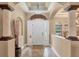 Bright foyer with a high decorative ceiling, tiled floor, columns, and a large front door at 15092 Chinook Way, Port Charlotte, FL 33981