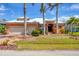 Elegant orange single-story home with manicured lawn and mature palm trees under a beautiful bright blue sky at 15092 Chinook Way, Port Charlotte, FL 33981