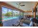 View of a screened lanai with outdoor seating and a pool overlooking the canal at 15092 Chinook Way, Port Charlotte, FL 33981