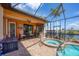 Covered patio featuring a built-in grill and pool area with a jacuzzi at 15092 Chinook Way, Port Charlotte, FL 33981