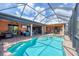Spacious screened-in pool area with a covered lanai, hot tub, and a view at 15092 Chinook Way, Port Charlotte, FL 33981