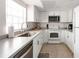 Bright kitchen features white cabinetry, stainless steel dishwasher, and complementing countertops at 1531 Placida Rd # 4-103, Englewood, FL 34223