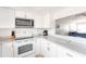Bright kitchen features white cabinetry, a microwave, and complementing countertops at 1531 Placida Rd # 4-103, Englewood, FL 34223