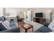 Well-lit living room featuring tile floors, a cozy sofa set, and a modern entertainment center at 1531 Placida Rd # 4-103, Englewood, FL 34223
