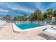 Inviting community pool area with comfortable lounge seating and beautiful blue skies at 1531 Placida Rd # 4-103, Englewood, FL 34223