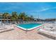 Community pool surrounded by lounge chairs and lush tropical landscaping for relaxation at 1531 Placida Rd # 4-103, Englewood, FL 34223
