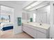 Bright bathroom with double vanity and shower, with view to Primary bedroom with a king bed at 162 Fairway Rd, Rotonda West, FL 33947