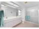Bright bathroom featuring a double sink vanity, spacious layout, and glass enclosed shower at 162 Fairway Rd, Rotonda West, FL 33947