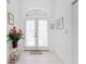 Bright foyer with tiled flooring, white walls, and double doors with sheer curtains leading to the main living area at 162 Fairway Rd, Rotonda West, FL 33947