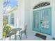 Inviting front porch with decorative chairs and a small table next to the charming double doors at 162 Fairway Rd, Rotonda West, FL 33947