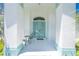 Charming front porch with turquoise double doors flanked by columns and decorated with an outdoor seating area at 162 Fairway Rd, Rotonda West, FL 33947