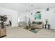 Bright and open living room with a ceiling fan, neutral carpeting, and large windows for plenty of natural light at 162 Fairway Rd, Rotonda West, FL 33947