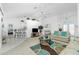 Bright living room features neutral decor, a ceiling fan, and access to kitchen and other rooms at 162 Fairway Rd, Rotonda West, FL 33947