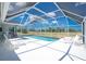 A screened in pool with lawn furniture is set against an open grassy field and a bright blue sky at 162 Fairway Rd, Rotonda West, FL 33947
