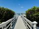 Scenic view down the private white wooden dock with clear skies and lush landscaping at 16716 Grande Quay Dr, Boca Grande, FL 33921