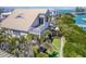 Coastal home with a large balcony, lush landscaping, and a glimpse of the sparkling ocean waters at 16716 Grande Quay Dr, Boca Grande, FL 33921
