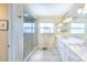 Bright main bathroom featuring double vanity, a glass enclosed shower, and tile flooring at 16716 Grande Quay Dr, Boca Grande, FL 33921