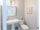 Cozy powder room featuring a pedestal sink and toilet at 16716 Grande Quay Dr, Boca Grande, FL 33921