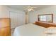Bright bedroom features a ceiling fan, closet, carpet, and wooden dresser with decorative mirror at 169 Fairway Rd, Rotonda West, FL 33947