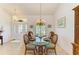 Elegant dining room featuring a glass table, decorative chandelier, and natural light from the front entry at 169 Fairway Rd, Rotonda West, FL 33947