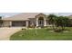 Charming single-story home featuring manicured lawn, a two car garage and an arched entryway at 169 Fairway Rd, Rotonda West, FL 33947