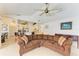Comfortable living room with large sofa, fan, and views into the kitchen and dining area at 169 Fairway Rd, Rotonda West, FL 33947