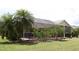 An ample screened-in patio with tropical landscaping provides a serene backyard living space at 169 Fairway Rd, Rotonda West, FL 33947
