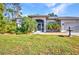 Charming home exterior featuring a screened front entry, mature landscaping, and a well-kept lawn at 1962 Remus Ave, North Port, FL 34286