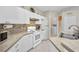 Bright kitchen features a range oven, a double sink, tile backsplash, and white cabinets at 1962 Remus Ave, North Port, FL 34286