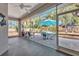 Enclosed patio with a dining table, chairs, and views of the lush backyard at 1962 Remus Ave, North Port, FL 34286