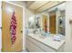 Bathroom vanity with a cream marble countertop and and mirrors at 204 Bunker Rd, Rotonda West, FL 33947