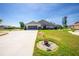 Beautifully landscaped home featuring lush green grass, an extended driveway, and a screened-in porch at 204 Bunker Rd, Rotonda West, FL 33947
