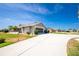 Well-maintained home with a long driveway leading to an attached garage and front entryway at 204 Bunker Rd, Rotonda West, FL 33947