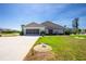 Well-maintained, single-story home with an attached garage, lush green lawn, and inviting curb appeal under a clear blue sky at 204 Bunker Rd, Rotonda West, FL 33947