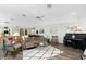 Open concept living room with wood floors, a ceiling fan, and a black piano at 204 Bunker Rd, Rotonda West, FL 33947