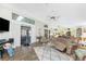 Bright living room with wood floors, a ceiling fan, and sliding glass doors to a screened in patio at 204 Bunker Rd, Rotonda West, FL 33947