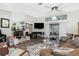 Living room with a fireplace, television, piano, ceiling fan, and sliding glass doors at 204 Bunker Rd, Rotonda West, FL 33947