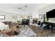 Bright living room with hardwood floors, a ceiling fan, and a cozy seating arrangement around a fireplace and multiple pianos at 204 Bunker Rd, Rotonda West, FL 33947