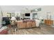 Open-concept living room features hardwood floors, high ceilings, a ceiling fan, and an abundance of natural light at 204 Bunker Rd, Rotonda West, FL 33947