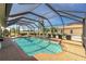 Sparkling screened-in pool with a well-maintained patio and lush landscaping at 204 Bunker Rd, Rotonda West, FL 33947